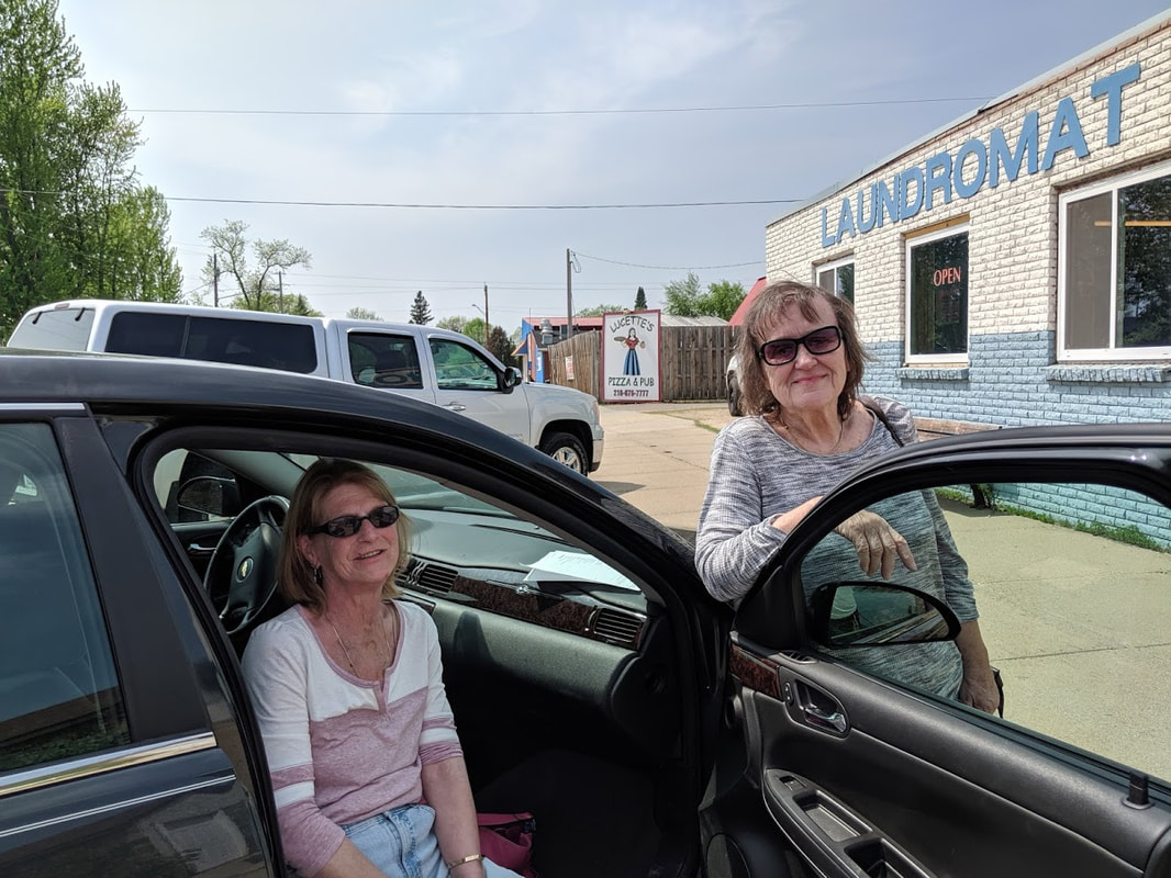 a female client recieving a ride from a female volunteer to the laundromat