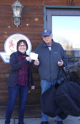   Faith in Action’s Data Coordinator Annette Bonin gives Volunteer Les Olson a gas card in thanks for his services to people in Cass County.